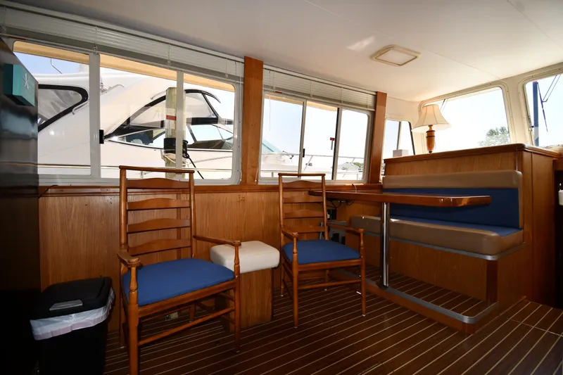 Make Me Smile Yacht Photos Pics Interior of 2006 Mainship 40 Trawler with wooden furniture and blue seating.