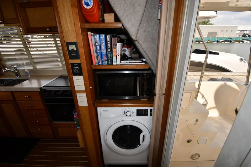Make Me Smile Yacht Photos Pics 2006 Mainship 40 Trawler interior with kitchen, washer, and books.
