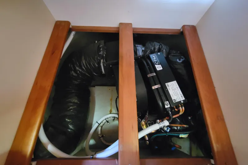 Make Me Smile Yacht Photos Pics Engine compartment of a 2006 Mainship 40 Trawler with visible components and hoses.