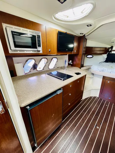 Seas The Day Yacht Photos Pics 2012 Cruisers 350 Express yacht interior with kitchenette and sleeping area.