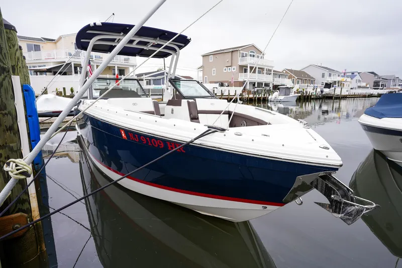 Plane To Sea Yacht Photos Pics 2022 Cobalt R8 boat docked in a marina, surrounded by waterfront homes.