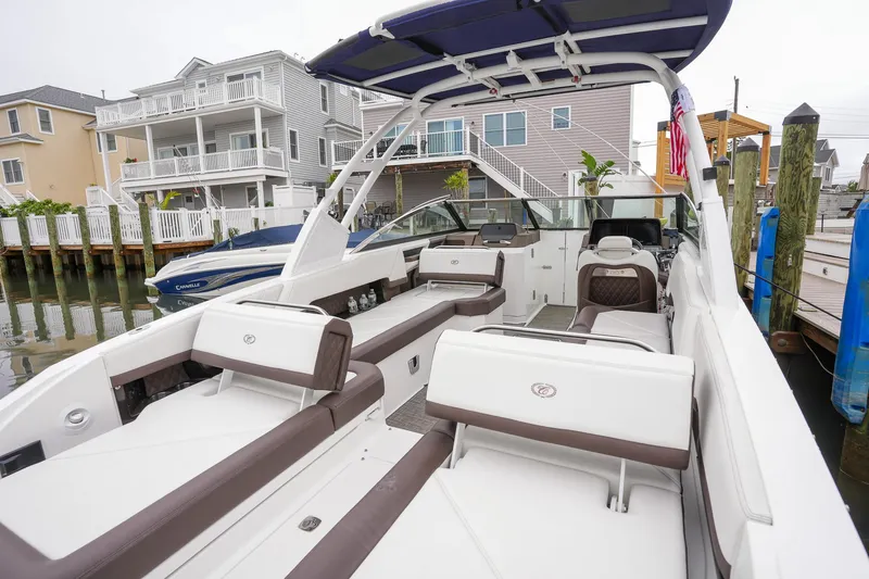 Plane To Sea Yacht Photos Pics 2022 Cobalt R8 boat with spacious seating, docked near waterfront homes.