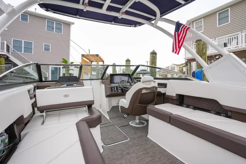 Plane To Sea Yacht Photos Pics 2022 Cobalt R8 boat interior with seating, helm, and American flag.