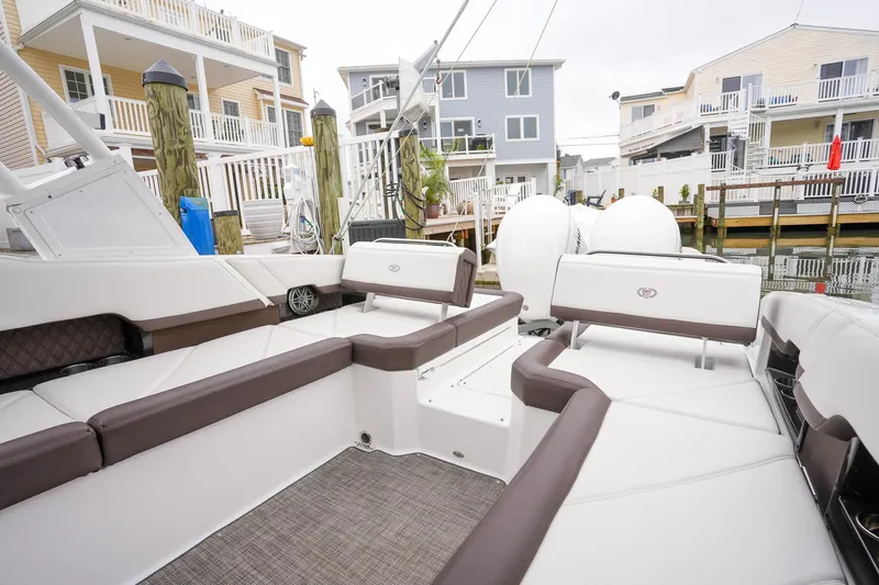 Plane To Sea Yacht Photos Pics 2022 Cobalt R8 boat interior with seating, docked near waterfront homes.