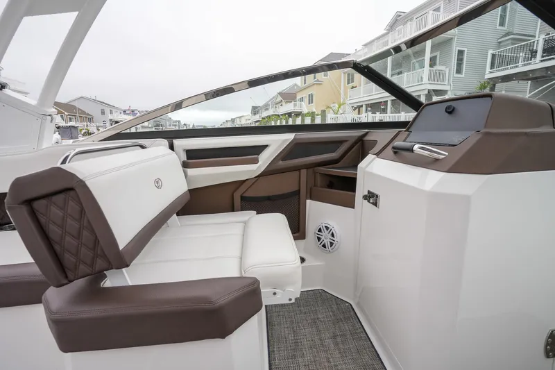 Plane To Sea Yacht Photos Pics 2022 Cobalt R8 boat interior with white and brown seating, modern dashboard, and waterfront view.