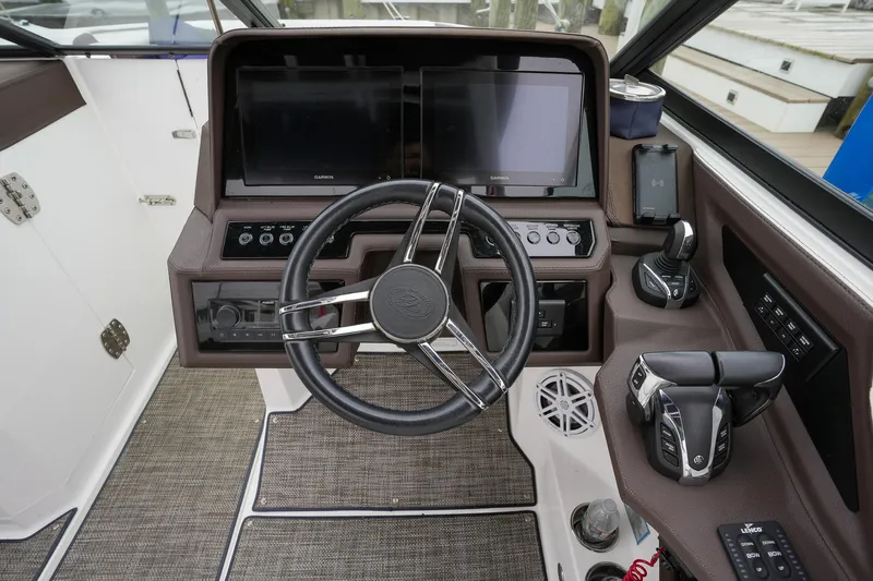 Plane To Sea Yacht Photos Pics 2022 Cobalt R8 boat cockpit with steering wheel, dual screens, and control panel.