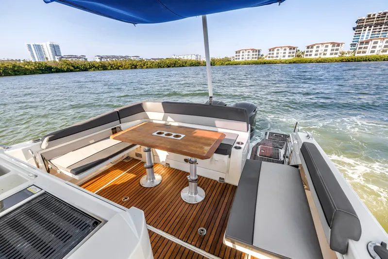  Yacht Photos Pics 2019 Jeanneau Leader 10.5 CC boat with spacious seating and wooden deck, cruising on a sunny day.