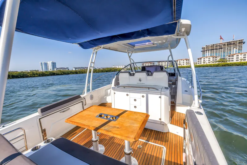  Yacht Photos Pics 2019 Jeanneau Leader 10.5 CC boat with spacious deck and seating, docked near waterfront buildings.