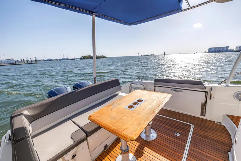  Yacht Photos Pics 2019 Jeanneau Leader 10.5 CC boat with seating and table, overlooking serene waters.