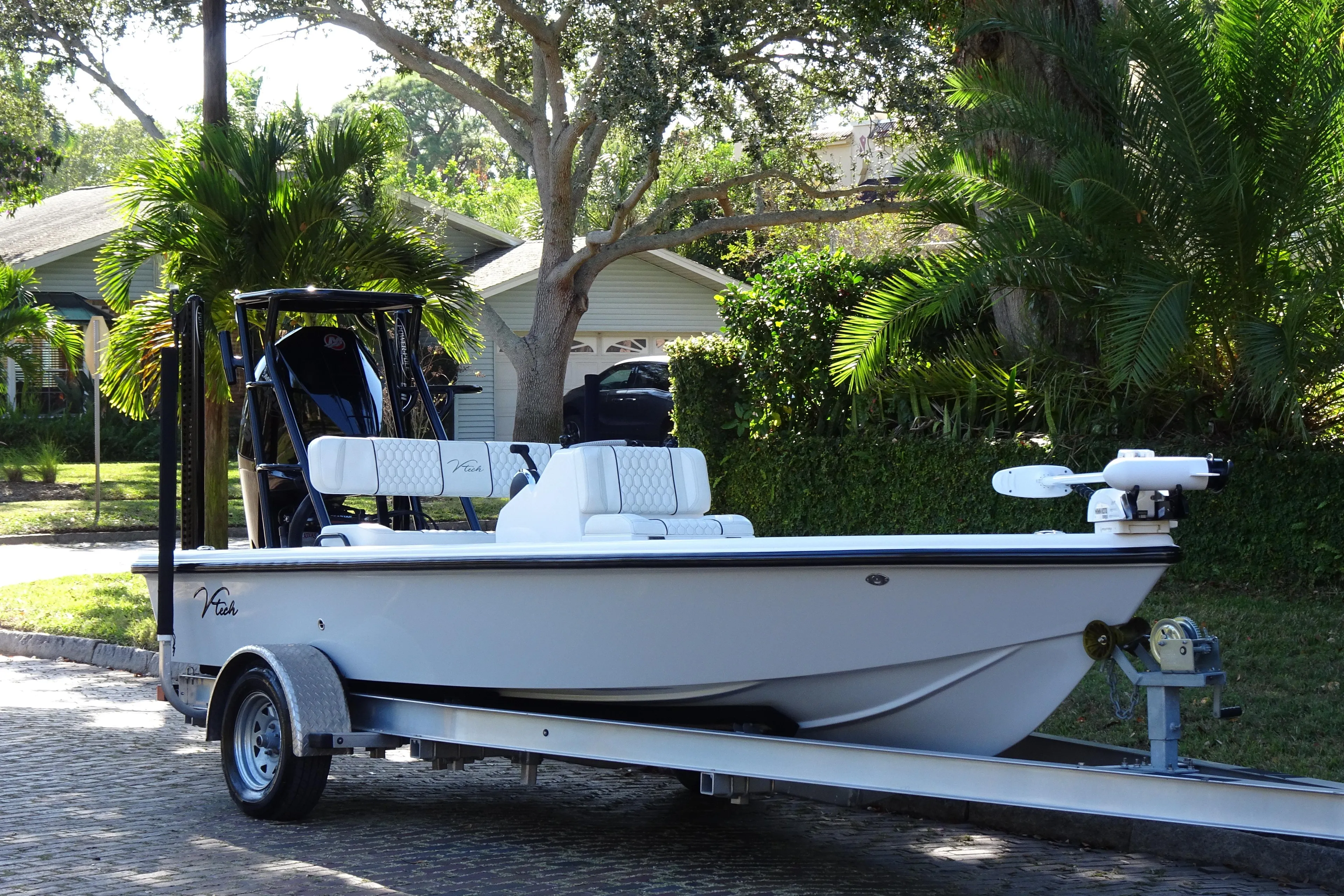 2023 Vtech 18 boat on trailer, parked in a lush residential area.