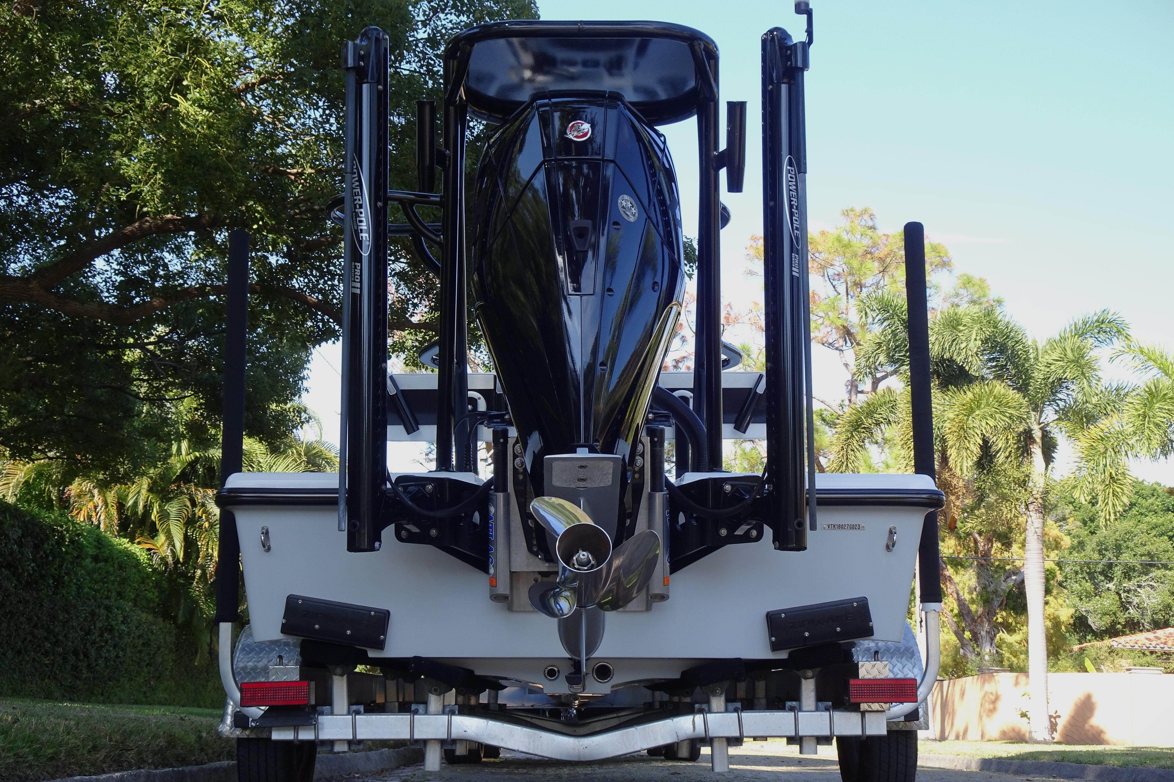 2023 Vtech 18 boat on trailer, rear view with trees in background.