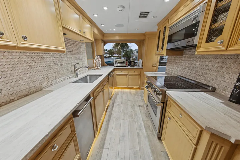 Savoir-faire Yacht Photos Pics Luxurious kitchen interior of 2002 Ocean Alexander 120 Megayacht with modern appliances and wood cabinetry.