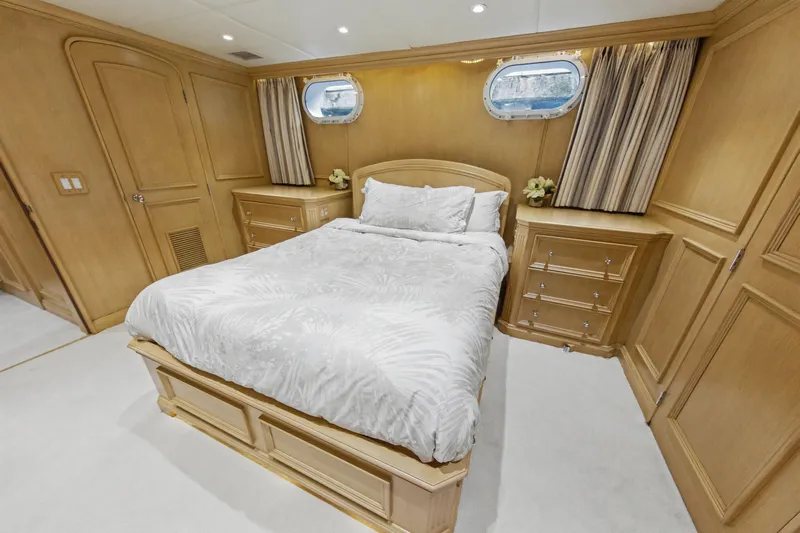 Savoir-faire Yacht Photos Pics Luxurious bedroom on 2002 Ocean Alexander 120 Megayacht with elegant wood paneling and cozy bedding.