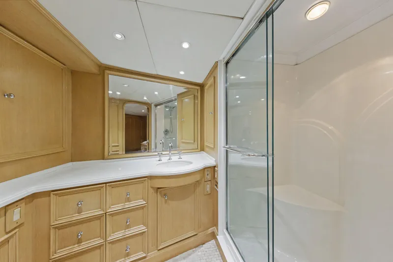 Savoir-faire Yacht Photos Pics Luxurious bathroom on 2002 Ocean Alexander 120 Megayacht with wooden cabinetry and glass shower.