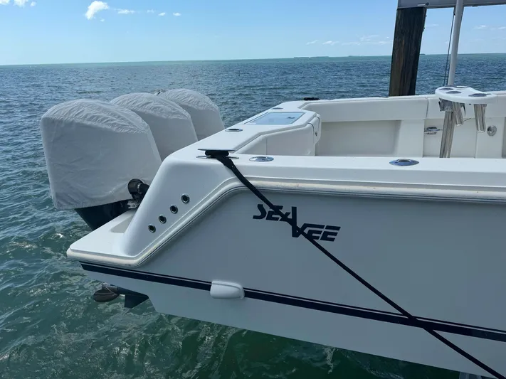 Warbird Yacht Photos Pics 2014 SeaVee 390B Center Console boat docked, featuring triple outboard engines.