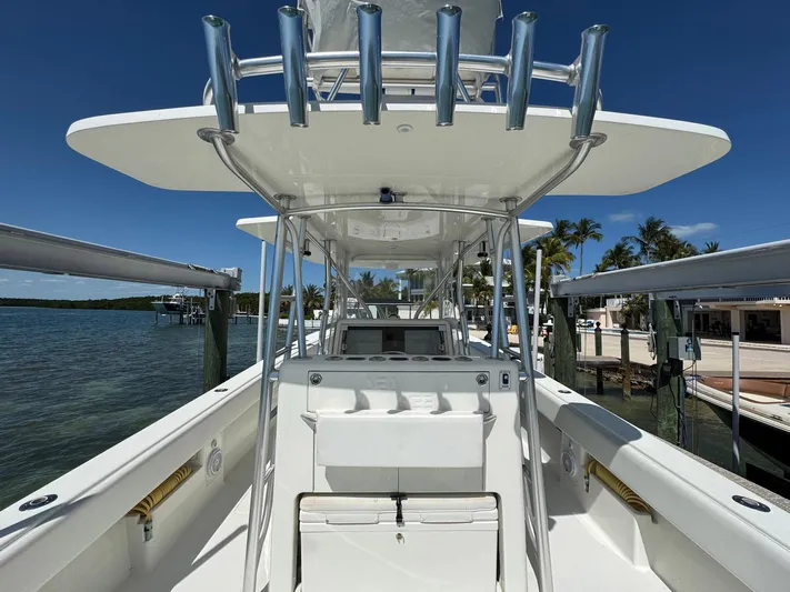 Warbird Yacht Photos Pics 2014 SeaVee 390B Center Console boat docked, showcasing helm and rod holders under clear blue sky.
