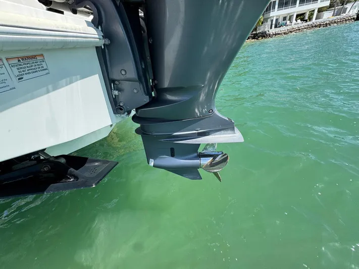Warbird Yacht Photos Pics Outboard motor of 2014 SeaVee 390B Center Console in clear green water.