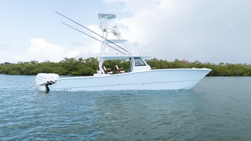  Yacht Photos Pics 2022 Freeman 43 boat on calm water with fishing rods and clear sky.