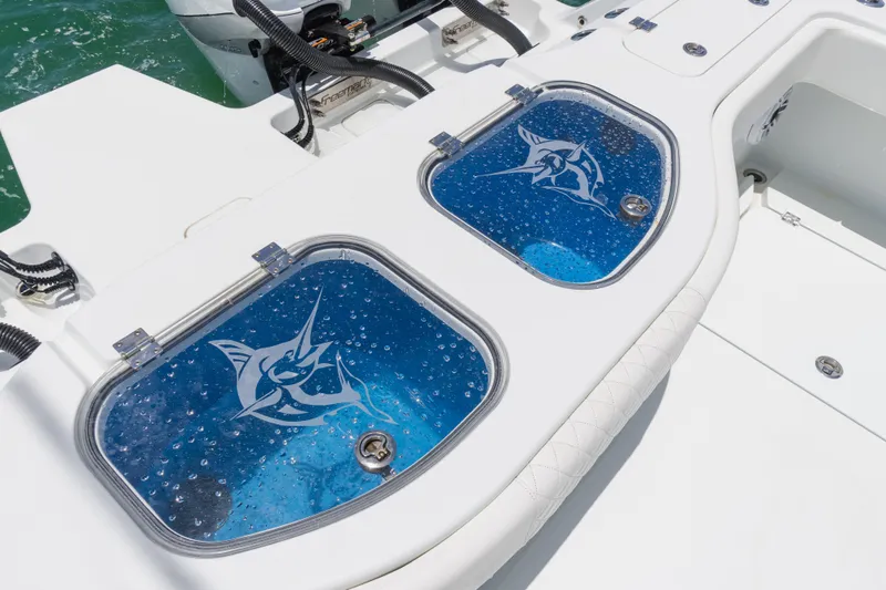  Yacht Photos Pics Livewell compartments on a 2022 Freeman 43 boat, featuring marlin graphics and clear lids.
