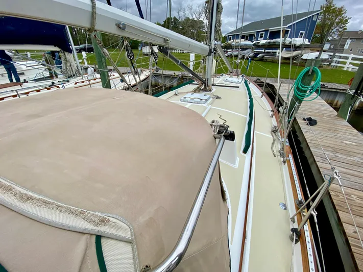 Private Idaho Yacht Photos Pics 1993 Cabo Rico 34 sailboat docked, featuring beige deck and green trim.