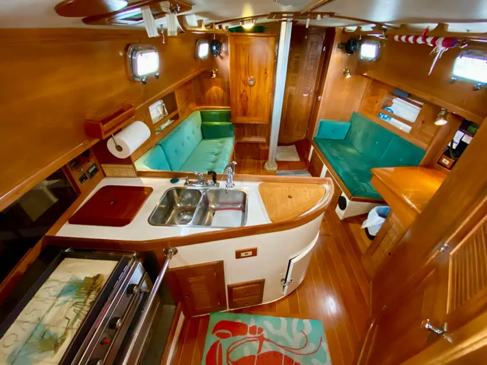Private Idaho Yacht Photos Pics Interior of 1993 Cabo Rico 34 sailboat with wood finish and teal seating.