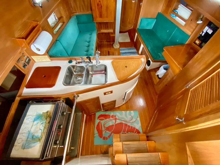 Private Idaho Yacht Photos Pics Interior of 1993 Cabo Rico 34 sailboat with wood finish and teal seating.
