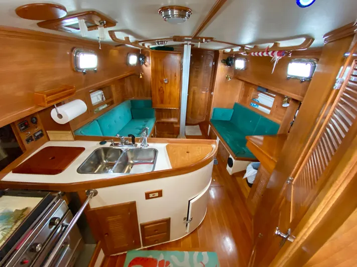 Private Idaho Yacht Photos Pics Interior of 1993 Cabo Rico 34 sailboat with wood finish and teal seating.