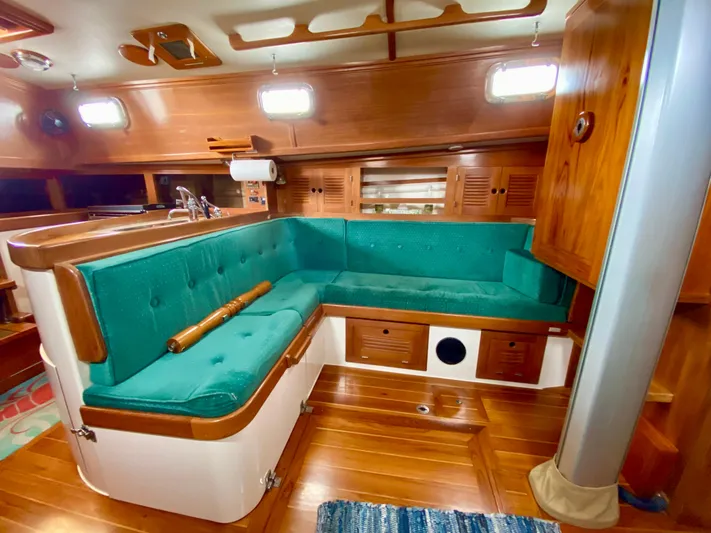 Private Idaho Yacht Photos Pics Interior of 1993 Cabo Rico 34 sailboat with teal seating and wooden finishes.