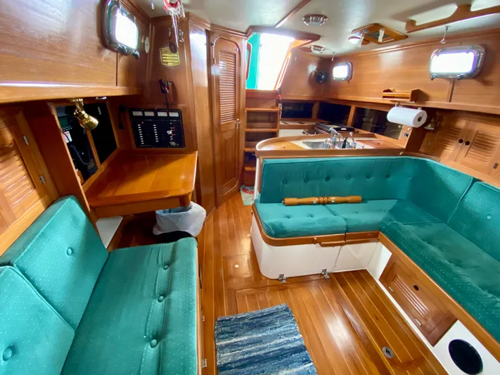 Private Idaho Yacht Photos Pics Interior of 1993 Cabo Rico 34 sailboat with teal seating and wooden finishes.