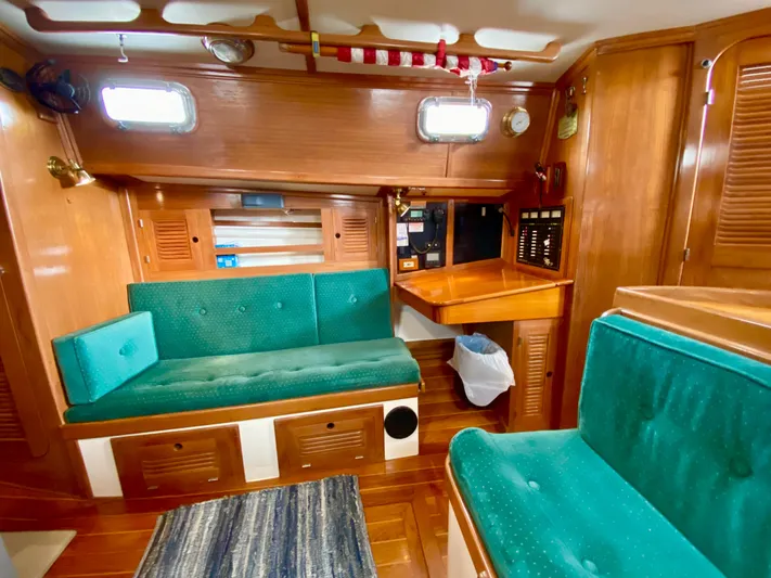 Private Idaho Yacht Photos Pics Interior of 1993 Cabo Rico 34 sailboat with wooden finish and green seating.