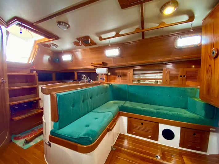 Private Idaho Yacht Photos Pics Interior of 1993 Cabo Rico 34 sailboat with teal seating and wooden finishes.