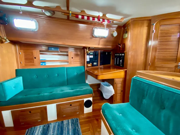 Private Idaho Yacht Photos Pics Interior of 1993 Cabo Rico 34 sailboat with teal seating and wooden cabinetry.