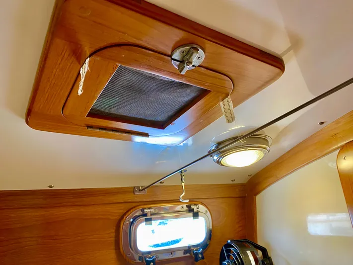 Private Idaho Yacht Photos Pics Interior of 1993 Cabo Rico 34 sailboat, featuring wooden hatch and porthole.