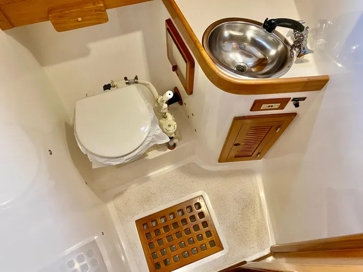 Private Idaho Yacht Photos Pics 1993 Cabo Rico 34 yacht bathroom with toilet, sink, and wooden accents.