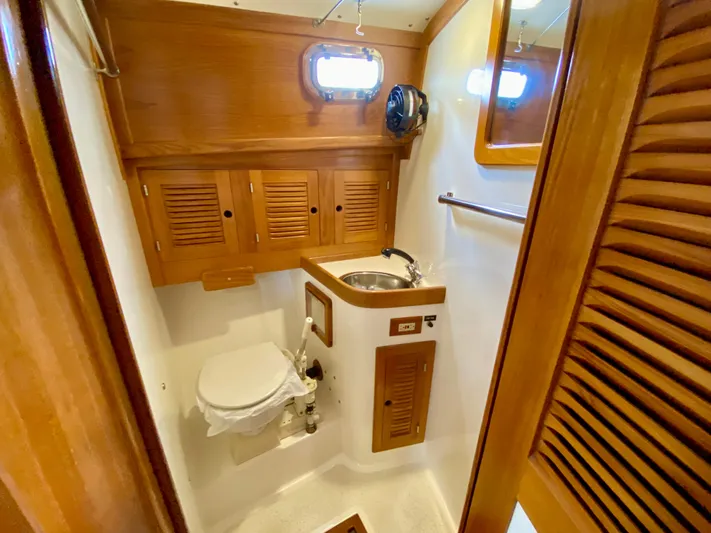 Private Idaho Yacht Photos Pics 1993 Cabo Rico 34 yacht bathroom with wooden cabinets, sink, and toilet.