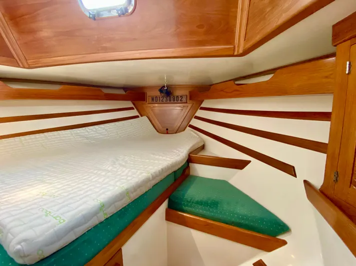 Private Idaho Yacht Photos Pics 1993 Cabo Rico 34 sailboat interior with wooden trim and cozy sleeping area.