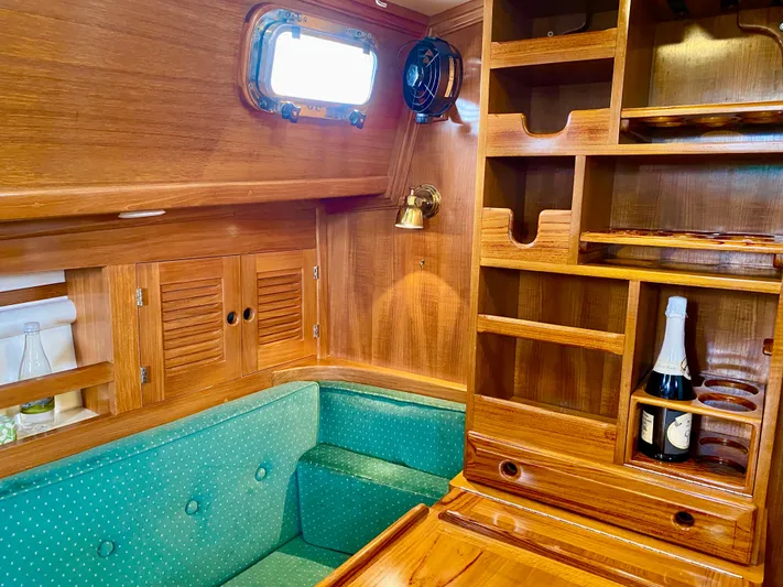 Private Idaho Yacht Photos Pics Interior of 1993 Cabo Rico 34 sailboat with wooden cabinetry and teal seating.