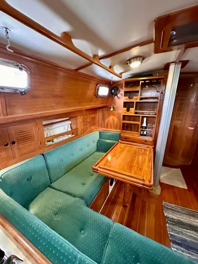 Private Idaho Yacht Photos Pics Interior of a 1993 Cabo Rico 34 sailboat with wooden furnishings and green seating.