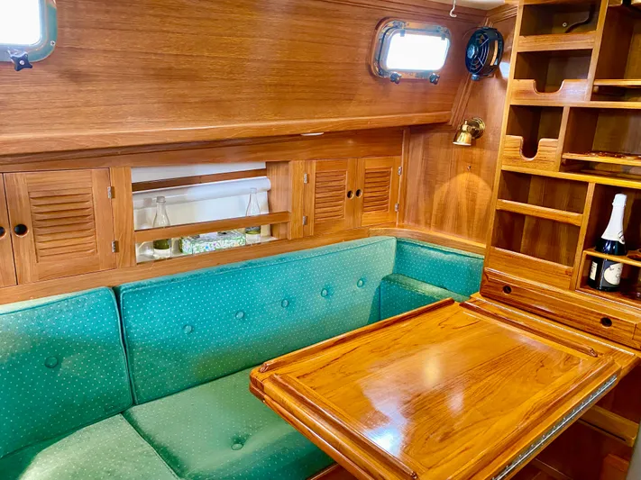 Private Idaho Yacht Photos Pics Cozy 1993 Cabo Rico 34 yacht interior with green seating and wooden table.