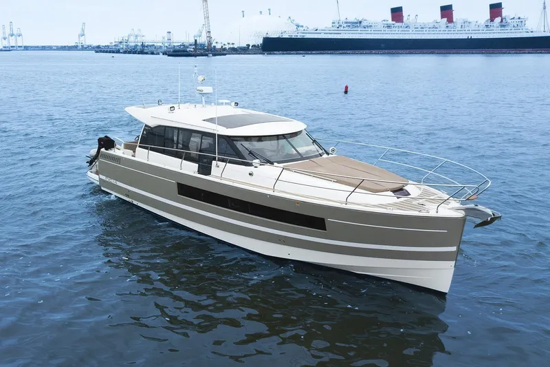 La Sirena Yacht Photos Pics 2014 Jeanneau NC 14 yacht cruising in a harbor with a large ship in the background.