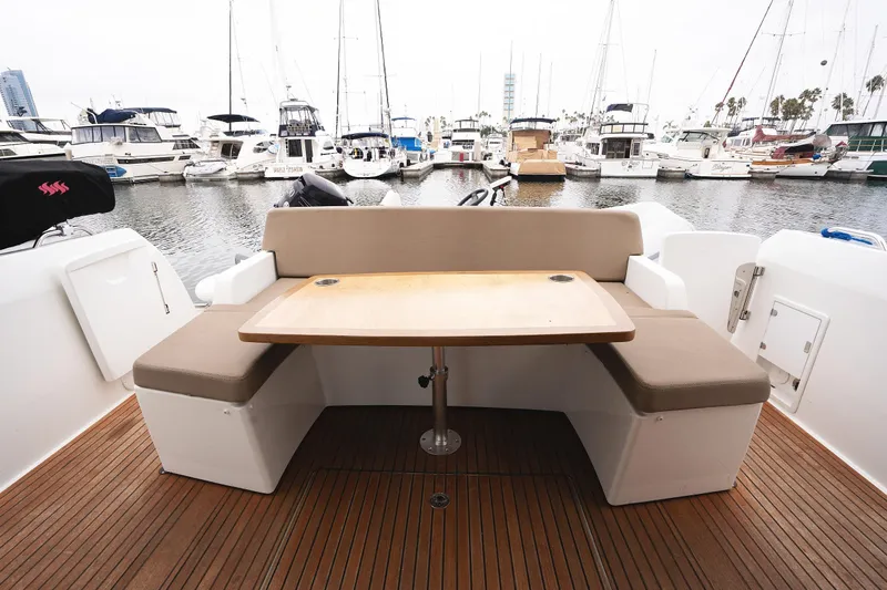La Sirena Yacht Photos Pics 2014 Jeanneau NC 14 yacht with outdoor seating and table, docked at marina.