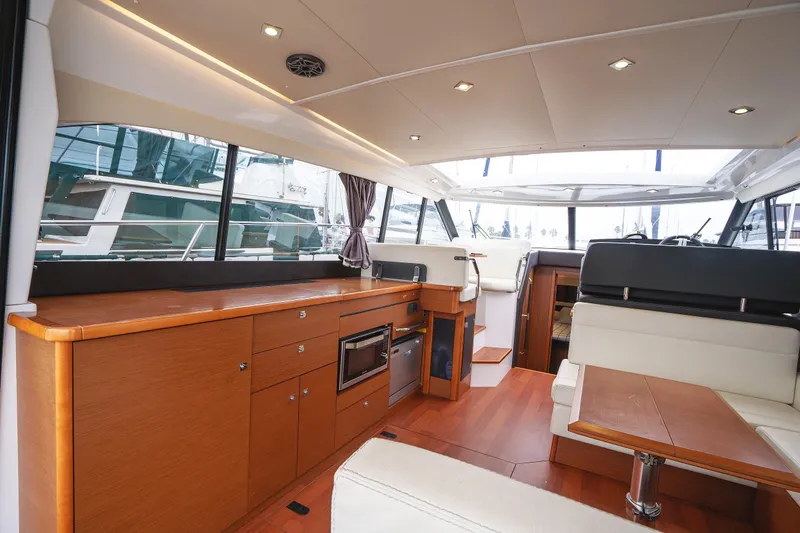 La Sirena Yacht Photos Pics Luxurious interior of 2014 Jeanneau NC 14 yacht with modern wood finishes and seating.