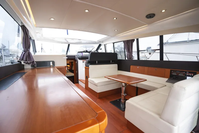 La Sirena Yacht Photos Pics Interior of 2014 Jeanneau NC 14 yacht with modern seating and wooden finishes.