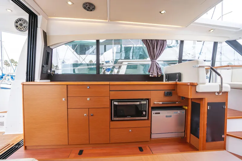 La Sirena Yacht Photos Pics Interior of 2014 Jeanneau NC 14 yacht with modern kitchen and wooden cabinetry.