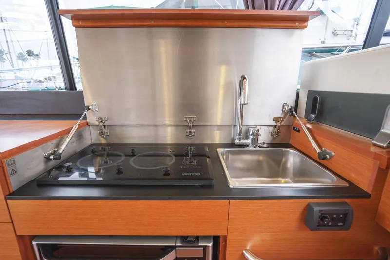 La Sirena Yacht Photos Pics 2014 Jeanneau NC 14 yacht kitchen with stove and sink, featuring modern design and functionality.