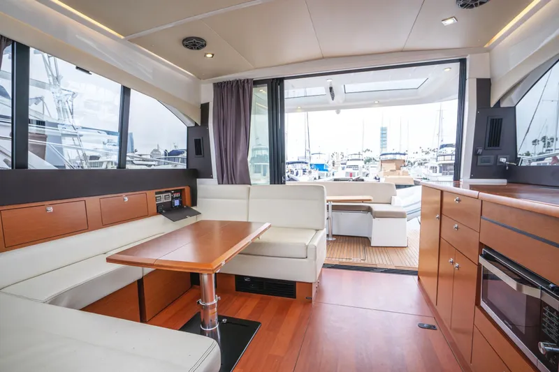 La Sirena Yacht Photos Pics Interior of 2014 Jeanneau NC 14 yacht with modern seating and wood finishes.
