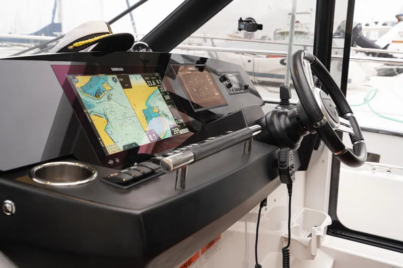 La Sirena Yacht Photos Pics 2014 Jeanneau NC 14 helm with navigation screens and steering wheel.