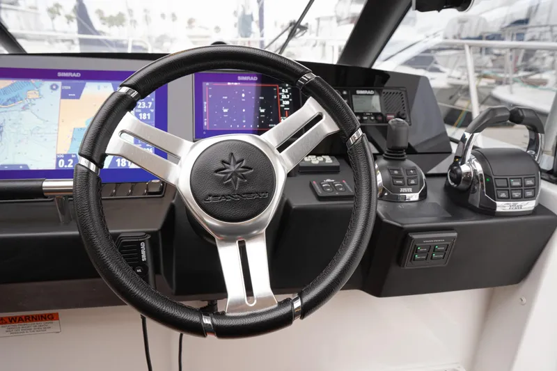La Sirena Yacht Photos Pics Steering wheel and controls of 2014 Jeanneau NC 14 boat with navigation displays.