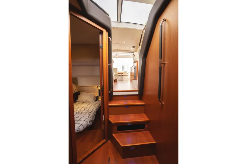 La Sirena Yacht Photos Pics Interior of 2014 Jeanneau NC 14 yacht, featuring wooden stairs and cozy cabin.