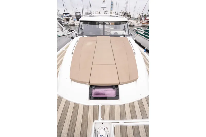 La Sirena Yacht Photos Pics 2014 Jeanneau NC 14 yacht with cushioned deck, docked in marina.